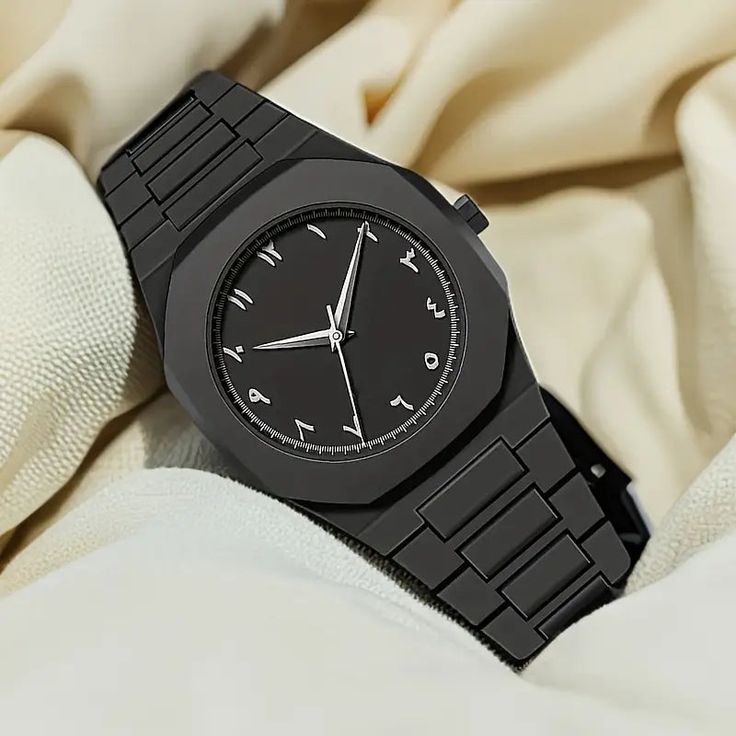 Black wristwatch with a metallic band on a beige fabric background