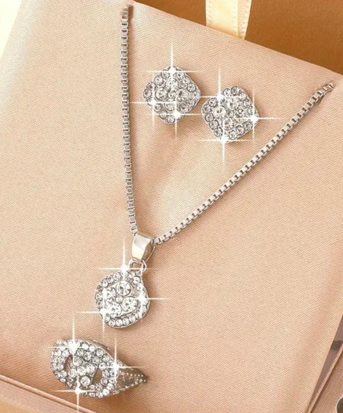 Silver jewelry set with necklace and earrings on a beige fabric background