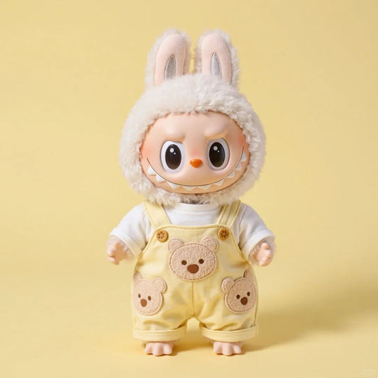 Toy figure with bunny ears and bear-themed overalls on a yellow background